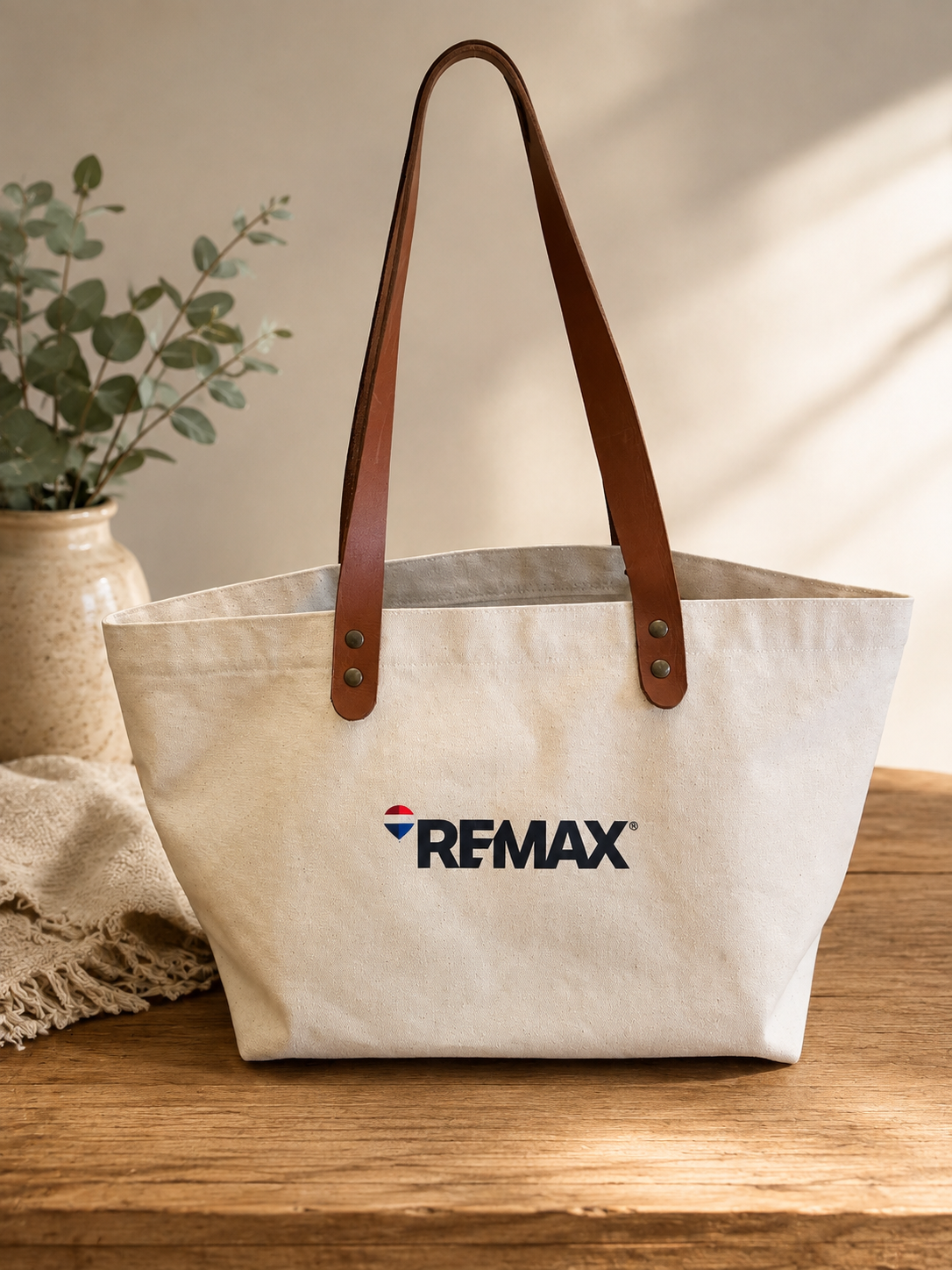Bolso de tela color natural con asas marrones y logotipo de RE/MAX